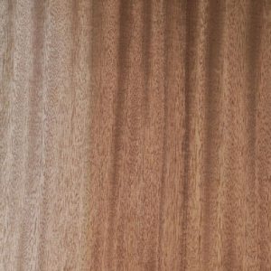 Close-up of wood surface showing vertical grain in light and dark brown tones.
